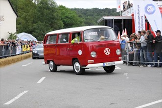Red VW bus driving on a road with spectators in the background, SOLITUDE REVIVAL 2011, Stuttgart,
