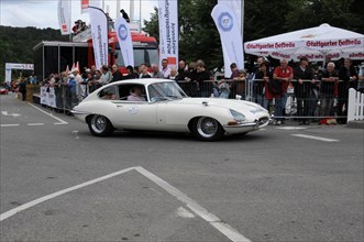 A white Jaguar E-Type classic car surrounded by spectators at a racing event, SOLITUDE REVIVAL
