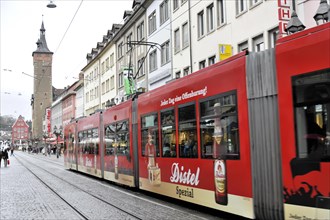 Wuerzburg, tram with advertisement drives through a busy shopping street in Wuerzburg, Wuerzburg,