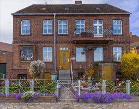 Brick house with flower-decorated front garden, Havelberg, Saxony-Anhalt, Germany, Europe