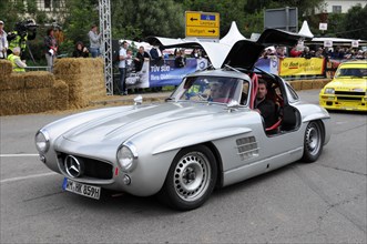 A silver Mercedes classic car with gullwing doors and starting number 417 at a festival, SOLITUDE