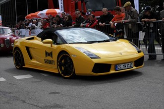 A yellow Lamborghini sports car presents itself to spectators during a car race, SOLITUDE REVIVAL