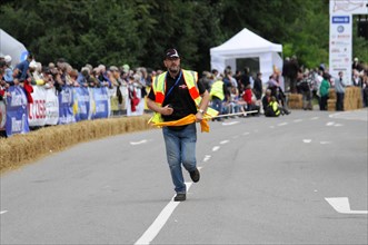 A person in a yellow safety waistcoat runs across a race track with a flag, SOLITUDE REVIVAL 2011,