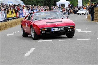 A red retro sports car drives past spectators, SOLITUDE REVIVAL 2011, Stuttgart,