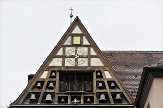 Wuerzburg, Gable of a building with clock and small carillon under a cloudy sky, Wuerzburg, Lower