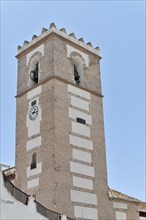 Solabrena, A tall white and brown clock tower stands proudly under a clear blue sky, Andalusia,
