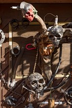 Old entrance door whimsically decorated, masks, skulls, engine parts, cartridge cases, tools, old