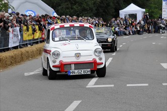 A small white and red racing car drives past a crowd of people, SOLITUDE REVIVAL 2011, Stuttgart,