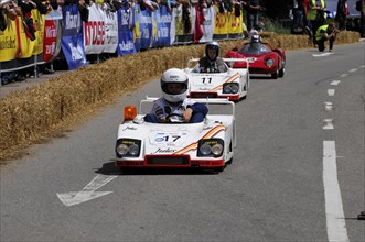 Two people in white racing suits steer their soapboxes during a race, SOLITUDE REVIVAL 2011,