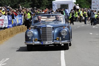 A blue Mercedes Cabriolet vintage car driving at an event, surrounded by spectators, SOLITUDE