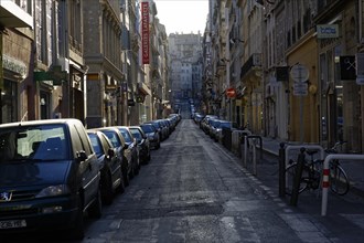 Marseille in the morning, An empty city street at dawn with parked cars and a bicycle, Marseille,
