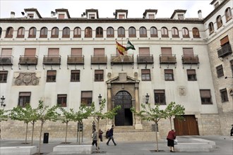 Jaen, Historic building with Spanish flag and newly planted trees in front of it, Jaen, Andalusia,