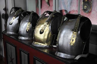Langenburg Castle, row of shiny metal helmets with chains on a red surface, Langenburg Castle,
