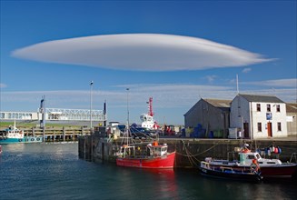UFO cloud over a small harbour with fishing vessels, Stromness, Orkney Islands, Scotland, UK
