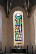 Speyer Cathedral, small altar with cross in front of a large stained-glass window and wall with a