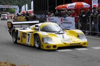 A yellow and black Porsche racing car with NEW MAN branding on a race track, SOLITUDE REVIVAL 2011,