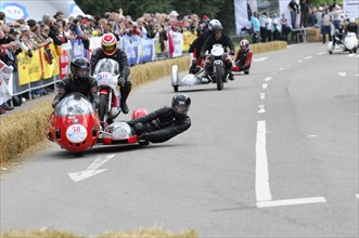 Several motorbikes with sidecars compete in a race in front of an audience, SOLITUDE REVIVAL 2011,