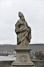 Saint Fridericus statue on the old Main bridge, Wuerzburg, stone statue of a bishop on a pedestal