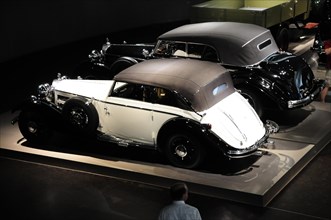 Two luxurious vintage cars in black and white under artificial light, Mercedes-Benz Museum,