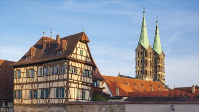 Towers of Bamberg Cathedral and half-timbered house in the evening light, Bamberg, Upper Franconia,