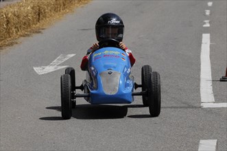 A child rides a blue soapbox in a race on a street, SOLITUDE REVIVAL 2011, Stuttgart,