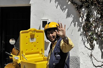 Solabrena, A smiling postman in a yellow uniform greets friendly while delivering the mail,
