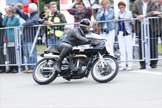 A motorbike racer in action, surrounded by spectators behind barriers, SOLITUDE REVIVAL 2011,
