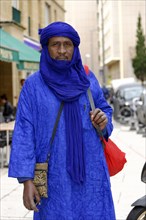 Businessman from Morocco, portrait of a man in traditional blue clothing and turban on the street,