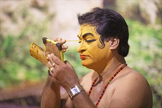 Kathakali performer or mime, 60 years old, makes up his face, Kochi Kathakali Centre, Kochi,