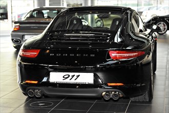 Rear view of a black Porsche 911 sports car in a showroom, Schwaebisch Gmuend, Baden-Wuerttemberg,
