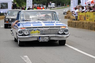 A blue and white Chevrolet classic car at a race with spectators in the background, SOLITUDE