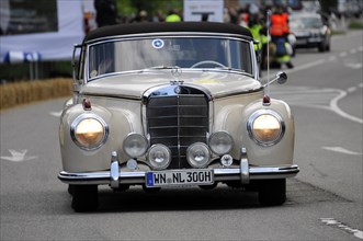 A white Mercedes-Benz classic car drives on a road during a rally, SOLITUDE REVIVAL 2011,