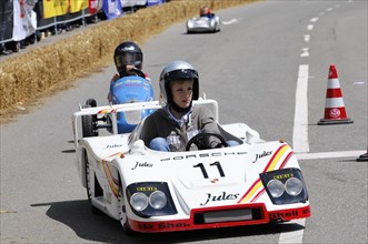 A racing driver in a white miniature racing car takes part in a race, SOLITUDE REVIVAL 2011,