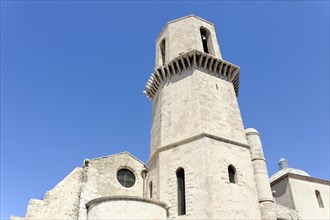 Marseille, Historic church under a clear blue sky with a massive stone tower, Marseille,