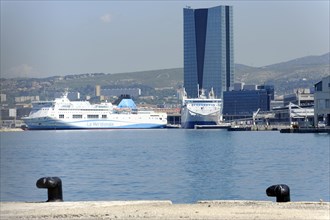CGA skyscraper, cruise ships in the harbour in front of a city skyline under a blue sky, a maritime