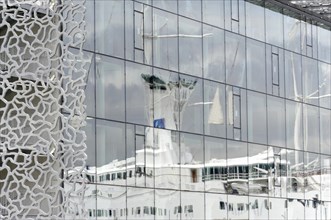 Marseille, Reflection of a sailing ship in the windows of a building with a modern, unusual facade,