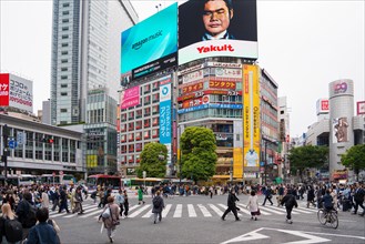 Digital billboards and pedestrians using the Shibuya Scramble Crossing, busy pedestrian