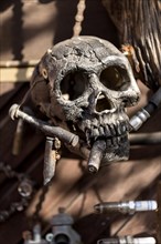 Old entrance door whimsically decorated, skull, engine parts, cartridge cases, tools, old town,