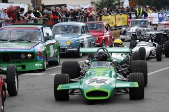 A green formula car on a race track surrounded by spectators, SOLITUDE REVIVAL 2011, Stuttgart,