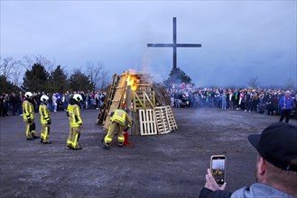 The fire brigade lights the Easter bonfire on the Haniel spoil tip in front of the summit cross,