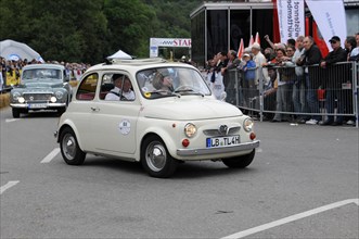 A small white vintage car drives on a road at an event, SOLITUDE REVIVAL 2011, Stuttgart,