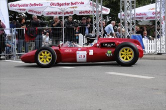 A red vintage racing car with sunshine and a driver in a yellow helmet, SOLITUDE REVIVAL 2011,
