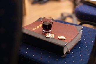 A Bible lies next to a filled glass on a table with a blue tablecloth, Bible Circle, Jesus Grace