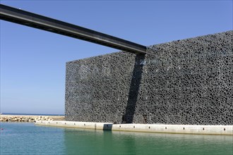 Marseille harbour, Modern building complex with sophisticated geometric facade next to calm sea