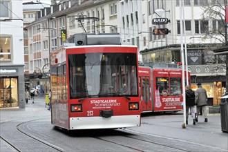 Wuerzburg, Red tram with advertising for Stadtgalerie runs in a pedestrian zone, Wuerzburg, Lower