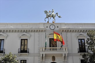 Granada, Horse statue on the roof of the town hall under a blue sky with flags, Granada, Andalusia,