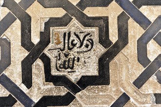 Artistic stone carvings, Alhambra, Granada, A mosaic with Islamic calligraphy in black and white on