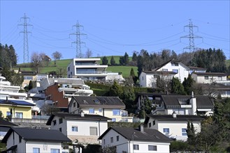 Multi-family houses on a slope with electricity pylons, Switzerland, Europe