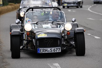 A black Caterham 7 sports car takes part in a racing event on a road, SOLITUDE REVIVAL 2011,