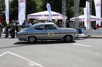 A silver-coloured classic car drives on a race track in front of spectators, SOLITUDE REVIVAL 2011,